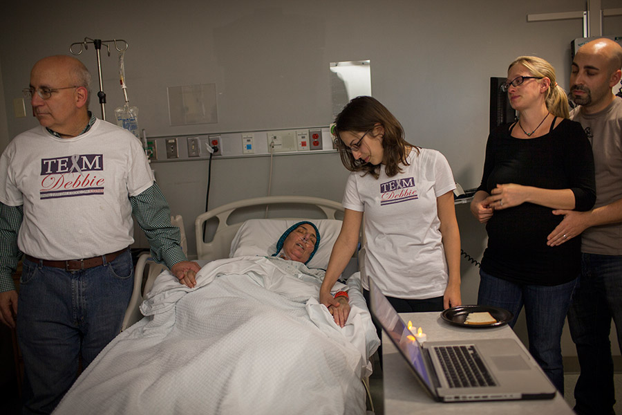 Ed, Debbie, Shira, Erin, and Elliot gather surrounded by a room full of family for Shabbat.